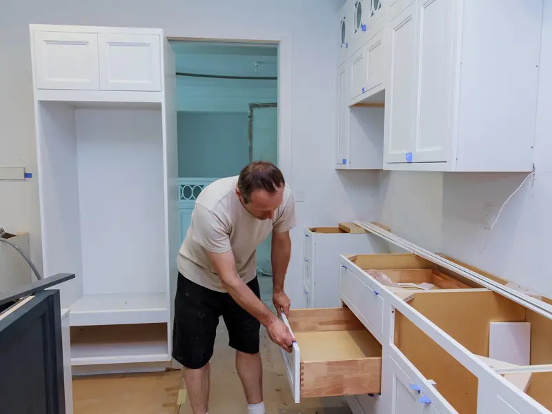Reinstalling a cabinet door after spraying in a Washington Township kitchen