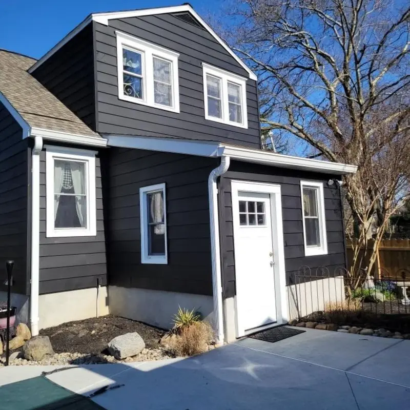 Two-story home painted charcoal with crisp white window trim and door