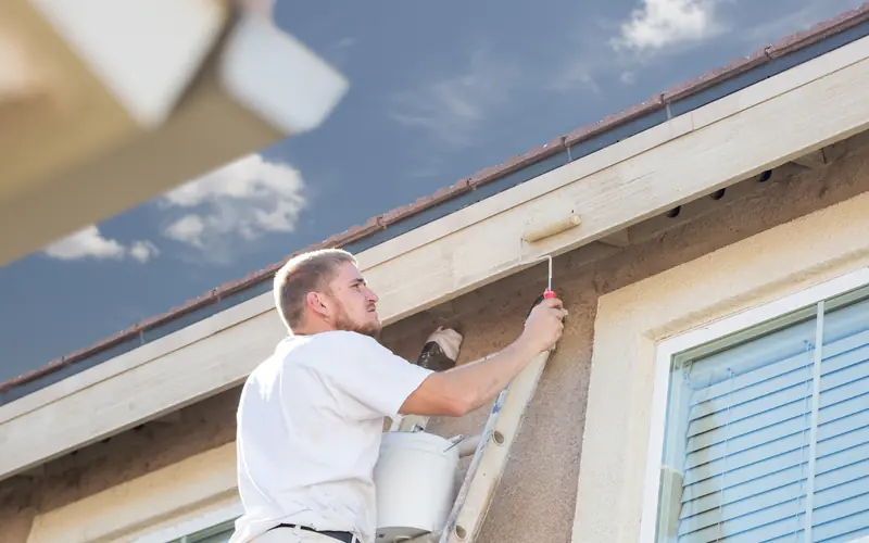 Painter brushing exterior trim on a colonial in Washington Township NJ
