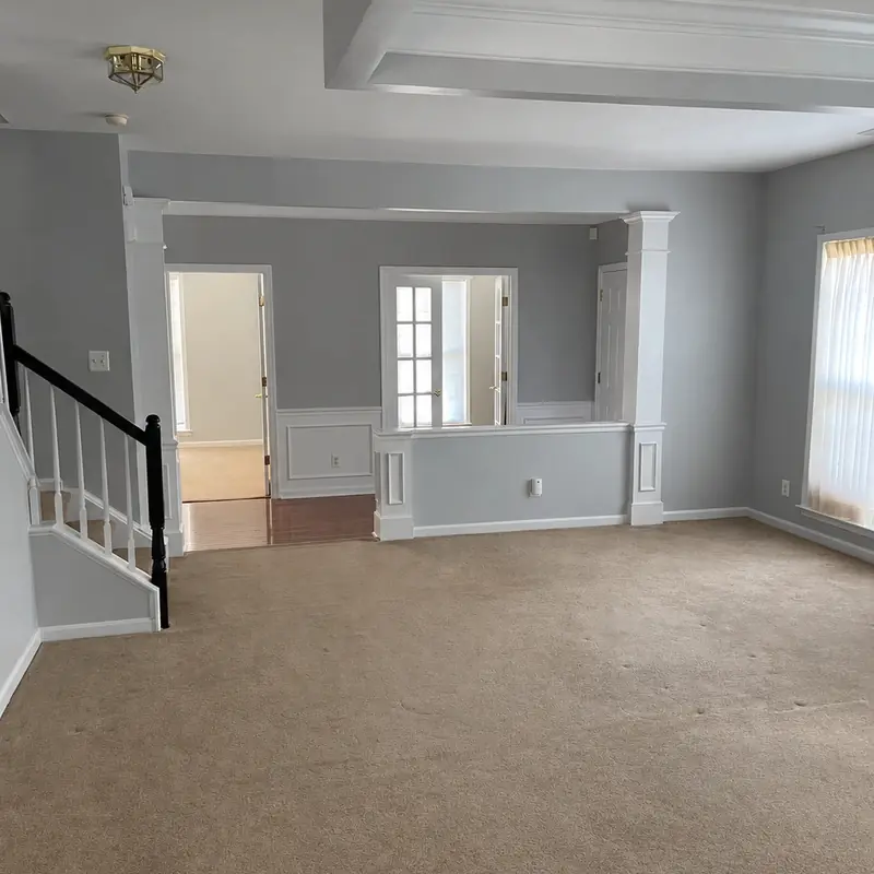Living room painted light gray with white coffered ceiling, trim, and wainscoting