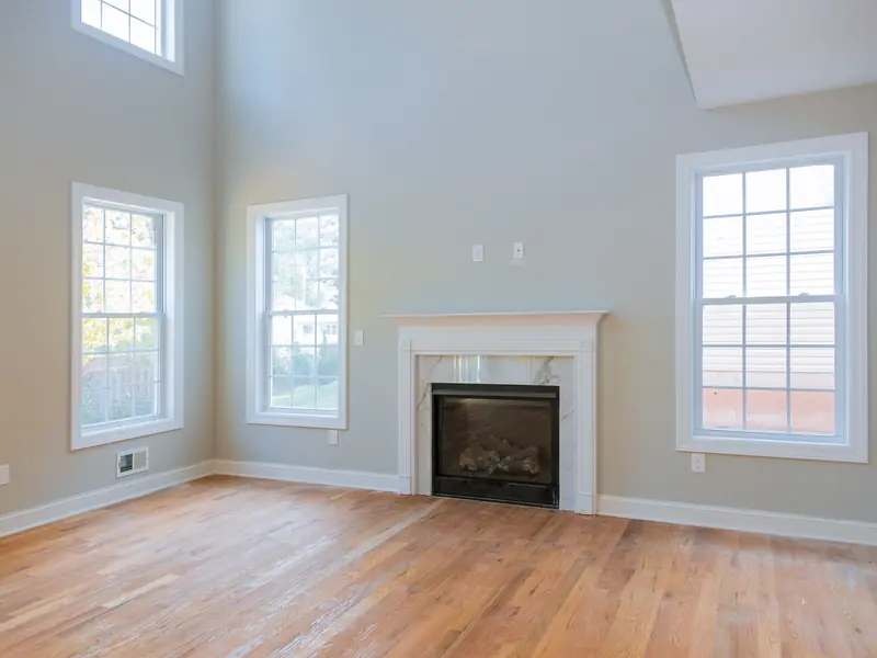 Living room in Sewell painted warm greige with white trim, afternoon light through the bay window