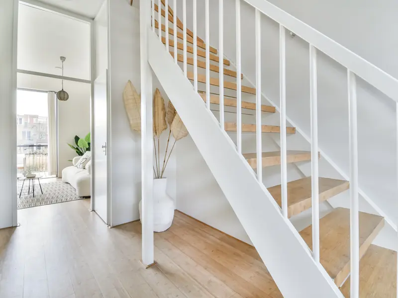 Bright open hallway and stairs with freshly painted white walls leading to the living room